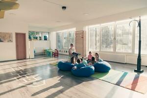 lesen Zeit im elementar Schule oder Kindergarten, Lehrer lesen ein Buch zu Kinder im elementar Schule oder Kindergarten. selektiv Fokus foto