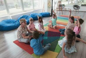 lesen Zeit im elementar Schule oder Kindergarten, Lehrer lesen ein Buch zu Kinder im elementar Schule oder Kindergarten. selektiv Fokus foto