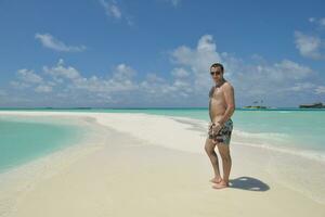 junger mann hat spaß und entspannt sich am strand foto