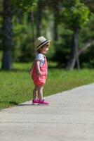 kleines Mädchen, das im Sommerpark läuft foto