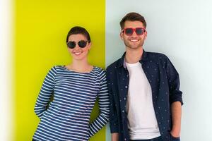 modern Mann und Mädchen tragen Sonnenbrille posieren isoliert im Vorderseite von bunt Hintergrund foto