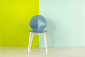 moderner blauer Stuhl vor einem blaugrünen Hintergrund foto