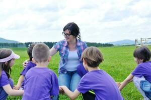 glückliche Kindergruppe mit Lehrer in der Natur foto