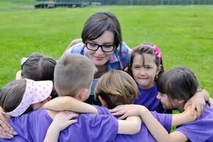 glückliche Kindergruppe mit Lehrer in der Natur foto