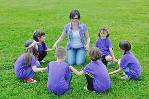 glückliche Kindergruppe mit Lehrer in der Natur foto