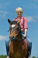 glückliche Frau auf dem Pferd foto