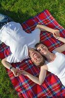 glückliches junges paar, das ein picknick im freien hat foto