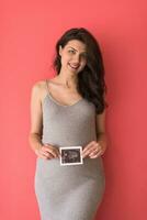 glückliche schwangere frau, die ultraschallbild zeigt foto