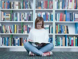 Schüler Mädchen lesen Buch im Bibliothek foto