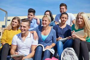 Studenten sitzen draußen auf Stufen foto