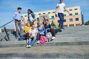 Studenten sitzen draußen auf Stufen foto