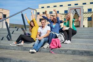 Studenten sitzen draußen auf Stufen foto