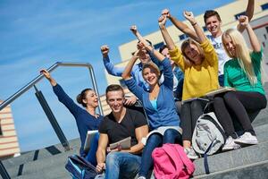 Studenten sitzen draußen auf Stufen foto