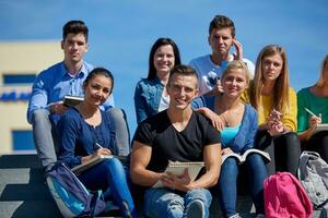 Studenten sitzen draußen auf Stufen foto