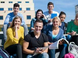 Studenten sitzen draußen auf Stufen foto