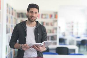 Porträt eines Schülers beim Lesen eines Buches in der Schulbibliothek foto