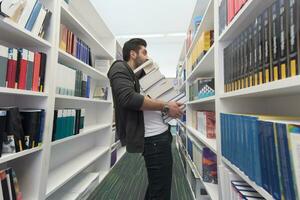 schüler, der viele bücher in der schulbibliothek hält foto