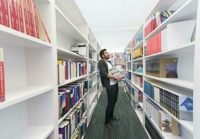 schüler, der viele bücher in der schulbibliothek hält foto