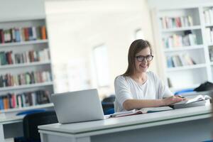 studentin studiert in der schulbibliothek foto