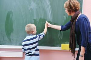 glücklicher kleiner junge im matheunterricht der ersten klasse foto