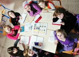 glückliche kinder mit lehrer im schulklassenzimmer foto