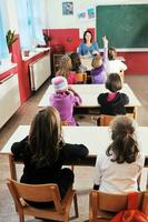 glückliche kinder mit lehrer im schulklassenzimmer foto