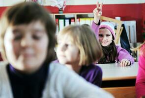 glückliche kinder mit lehrer im schulklassenzimmer foto