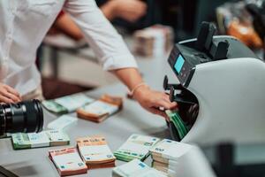 Bank Angestellte mit Geld Zählen Maschine während Sortierung und Zählen Papier Banknoten Innerhalb Bank Gewölbe. groß Beträge von Geld im das Bank foto