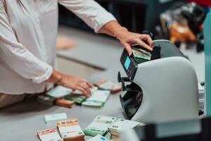 Bank Angestellte mit Geld Zählen Maschine während Sortierung und Zählen Papier Banknoten Innerhalb Bank Gewölbe. groß Beträge von Geld im das Bank foto