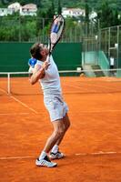 mann spielt tennis im freien foto