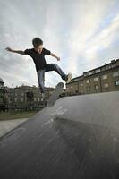 Junge übt Skate in einem Skatepark foto