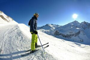 Skifahren auf Neuschnee in der Wintersaison am schönen sonnigen Tag foto