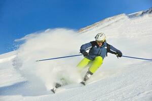 Skifahren auf Neuschnee in der Wintersaison am schönen sonnigen Tag foto