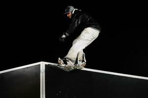 Freestyle-Snowboarder springen nachts in die Luft foto