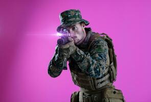 Soldat im Aktion Zielen Laser Sicht Optik Rosa Hintergrund foto