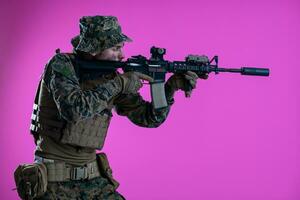 Soldat im Aktion Zielen Laser Sicht Optik Rosa Hintergrund foto