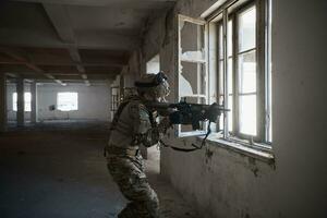 Soldat in Aktion in der Nähe des Fensterwechselmagazins und in Deckung gehen foto