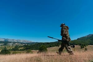 Heer Soldat halten ein Scharfschütze Gewehr mit Umfang und Gehen im das Wald. Krieg, Armee, Technologie und Menschen Konzept. foto