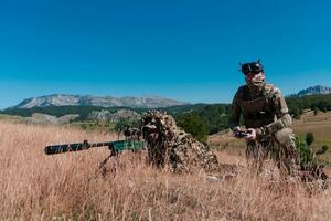 Scharfschütze Soldat unterstützt durch ein Assistent zu beobachten das Bereich zu Sein gezielt mit modern Krieg taktisch virtuell Wirklichkeit Brille Antenne Drohne Militär- Technologie. foto