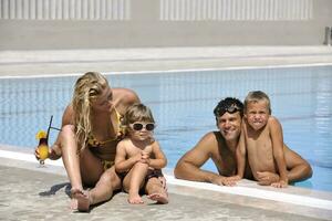 glückliche junge familie hat spaß am schwimmbad foto