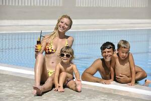 glückliche junge familie hat spaß am schwimmbad foto