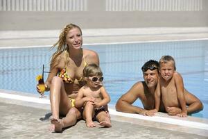 glückliche junge familie hat spaß am schwimmbad foto