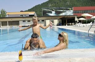 glückliche junge familie hat spaß am schwimmbad foto