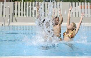 glückliche junge familie hat spaß am schwimmbad foto