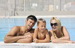 glückliche junge familie hat spaß am schwimmbad foto