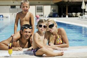 glückliche junge familie hat spaß am schwimmbad foto