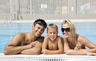 glückliche junge familie hat spaß am schwimmbad foto