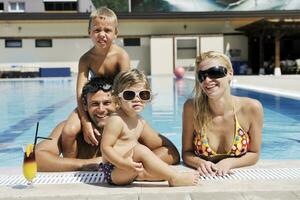 glückliche junge familie hat spaß am schwimmbad foto