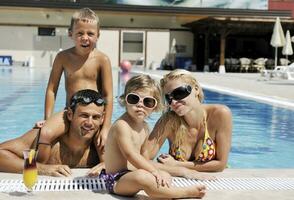 glückliche junge familie hat spaß am schwimmbad foto