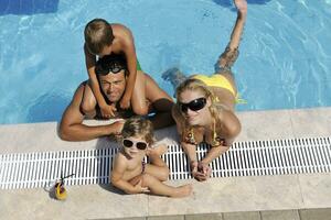 glückliche junge familie hat spaß am schwimmbad foto